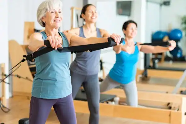 Toning Arms After 60: Empowering Womens Fitness Through Effective Weight Training 2 older woman doing weight training Leighton Buzzard and resistance in the gym to tone upper arms