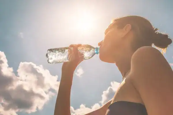 Hydration: The Secret Ingredient for a Toned Stomach and Enhanced Fitness 3 Image of woman drinking water to hydrate Leighton Buzzard after run.