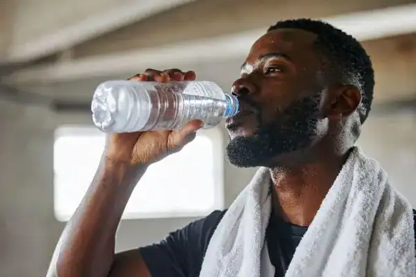 Hydration: The Secret Ingredient for a Toned Stomach and Enhanced Fitness 1 Image of man drinking water to improve hydration Leighton Buzzard after work out.